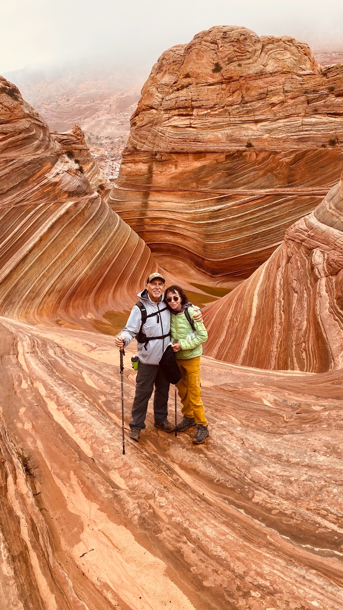 Marc and Kippy standing together among sweeping red sandstone formations.